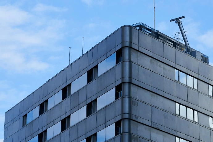 Modern concrete building with reflective windows against sky